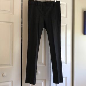 Dark pants with back pocket buttons